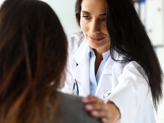 doctora-coloca-sus-manos-sobre-los-hombros-de-una-mujer-muestra-de-afecto-carino