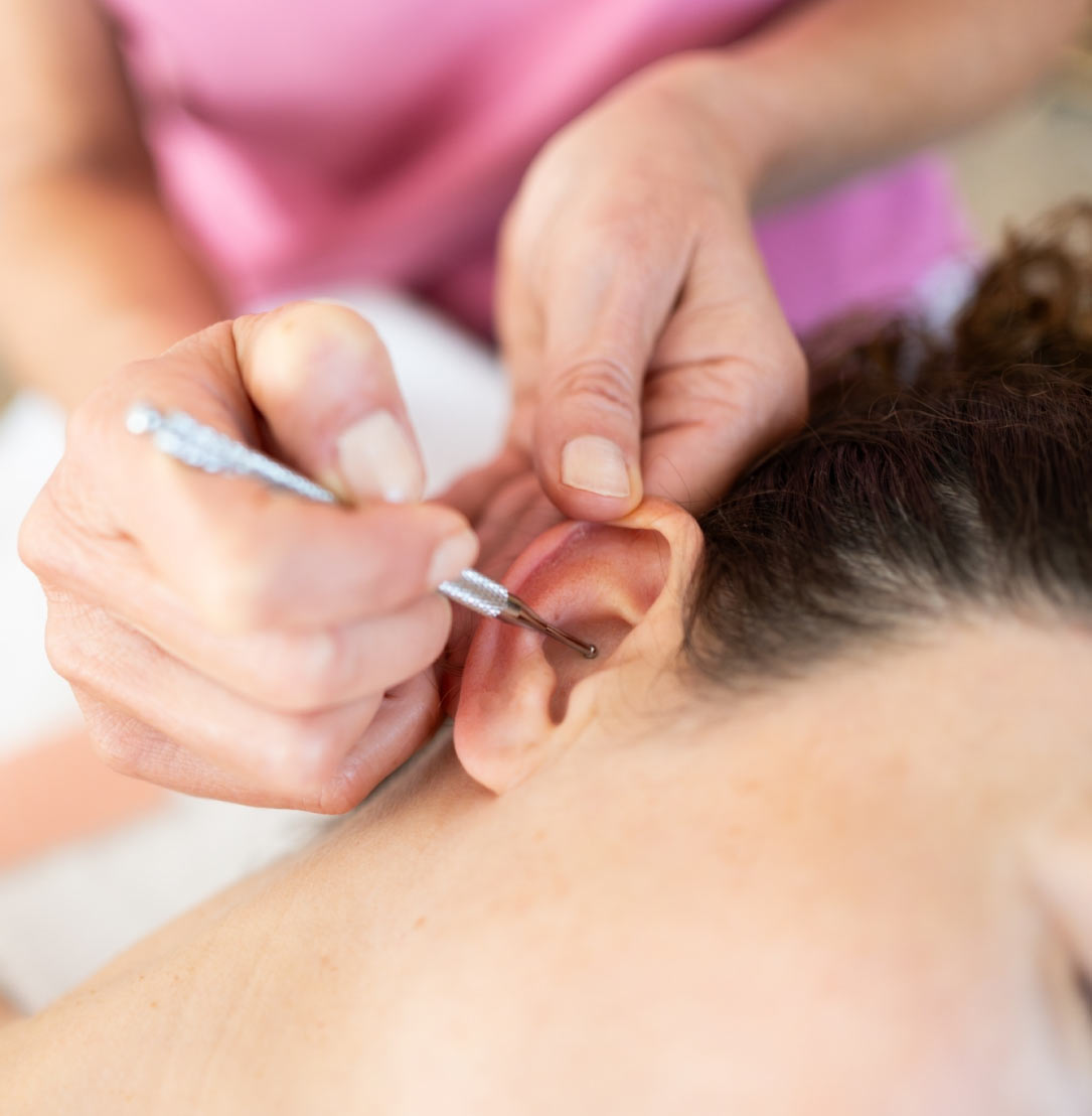 masajista-aplica-un-lapiz-de-masaje-en-la-oreja-durante-la-sesion-de-auriculoterapia-en-lima-peru