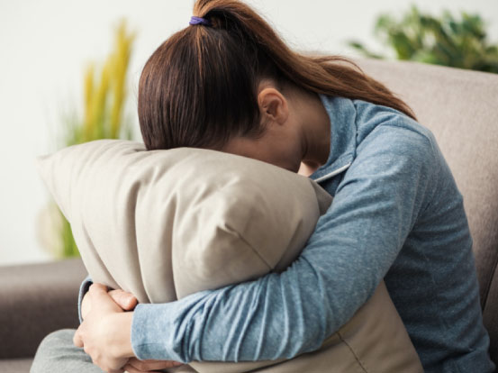 mujer-con-la-cabeza-inclinada-sobre-una-almohada-muestra-tristeza-depresion