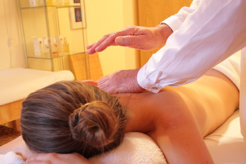 mujer-rescostada-recibe-masajes-en-la-espalda-auriculoterapia-y-nutricion